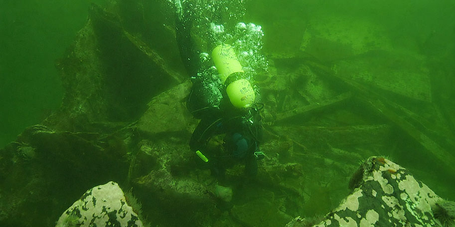 Plongeur au-dessus d'une épave sous-marine